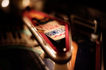 thomas-millot-CbxaLzCVsCM-Kicker close up of a lit pinball kicker/bumper