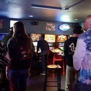 People waiting their turn to play pinball